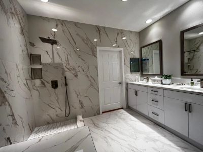 Modern bathroom with marble tiles, walk-in shower, and double vanity.