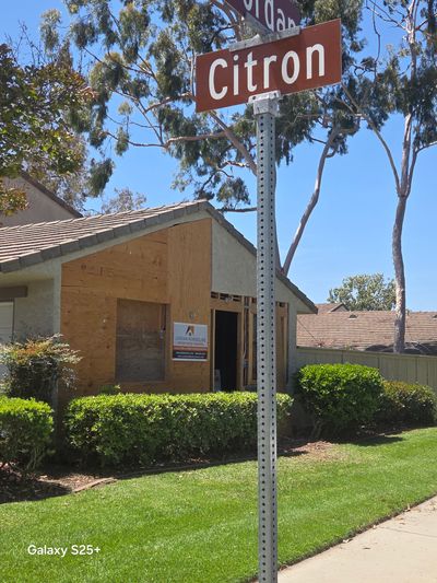Street sign for Citron near a house under renovation on a sunny day.