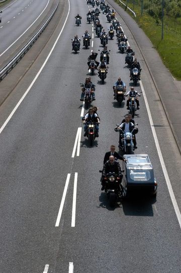 Motorcycle hearse leading a large group of motorcycles