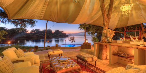 African safari luxury tent with a view of the sunset over the Chombe River