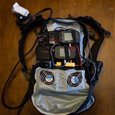 Modems, fans, and batteries inside backpack