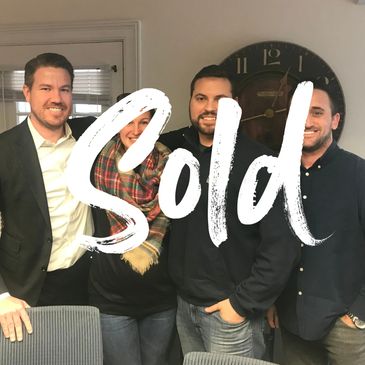 Four people smiling indoors with the word 'Sold' overlayed in white.