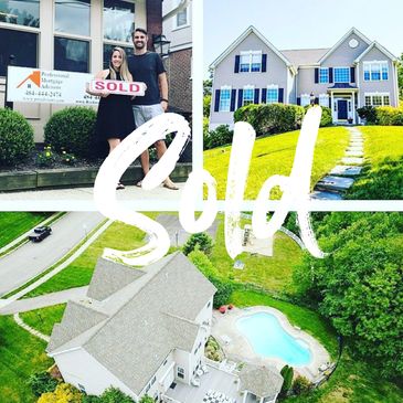Happy couple holding a sold sign outside their new home.