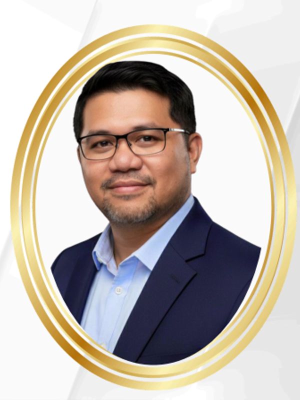 Man in glasses and suit smiling.