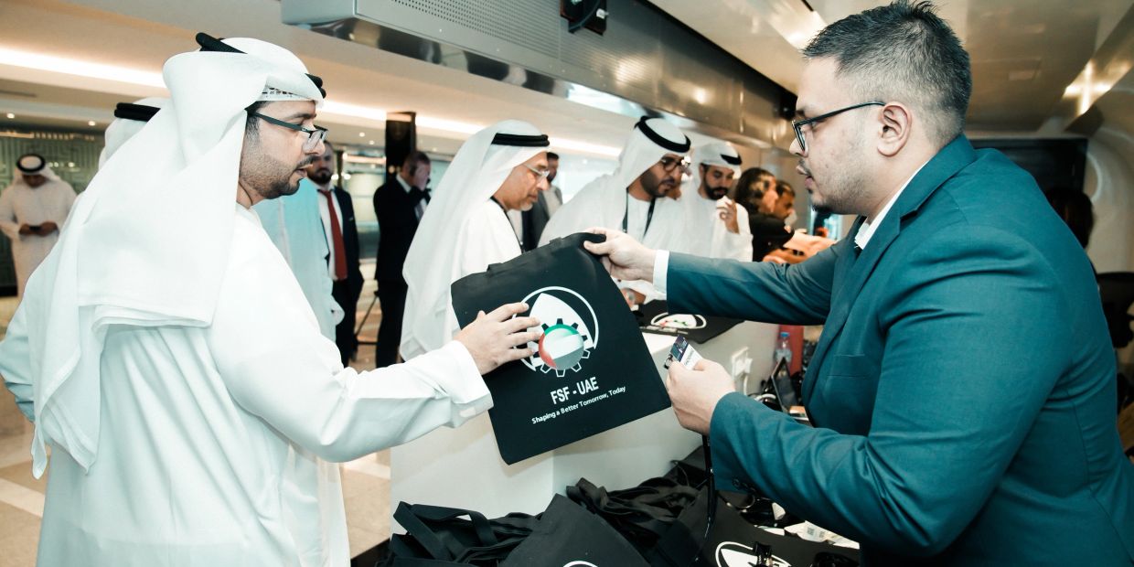 Two men exchanging a bag at a formal event.