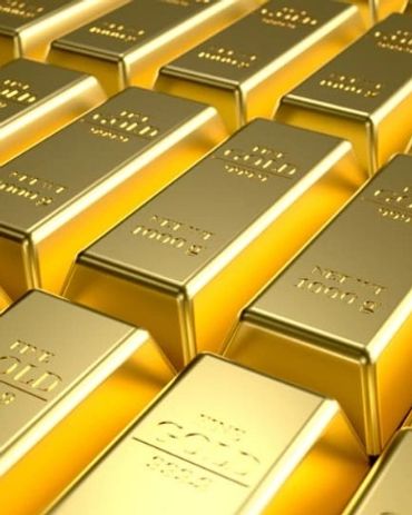 Stacks of shiny gold bars arranged in rows.