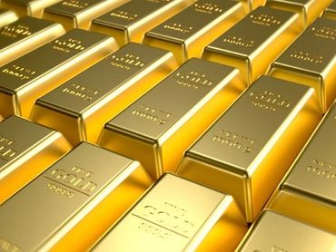 Stacks of shiny gold bars arranged in rows.