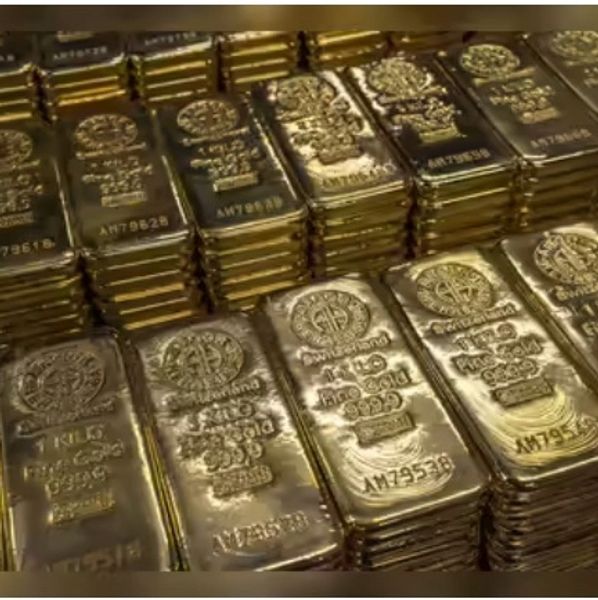 Stacks of shiny gold bars arranged in neat piles.