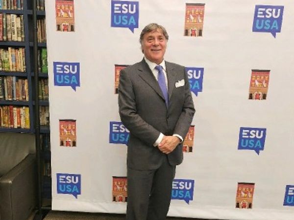 Man in a suit standing in front of an ESU USA backdrop.