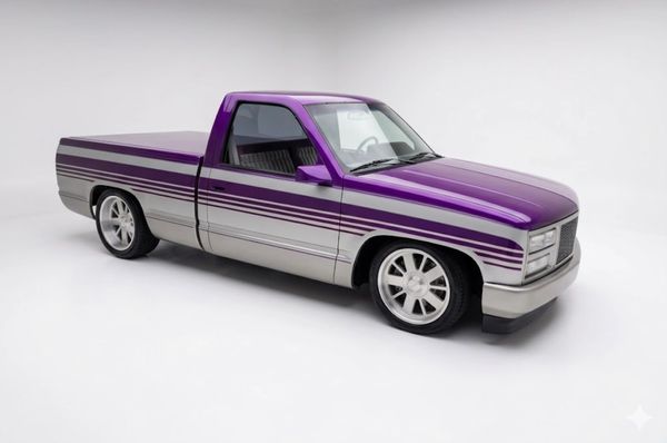Purple and silver custom pickup truck with racing stripes and lowered suspension.