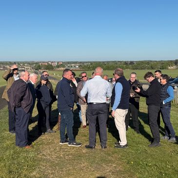 Group of men talking outdoors on a sunny day.