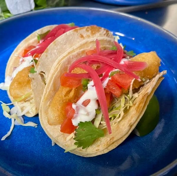 Fried FIsh Tacos topped with pickled red onions, and cilantro crema