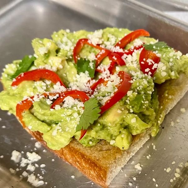 Fresh smashed avocado toast with pickled red peppers