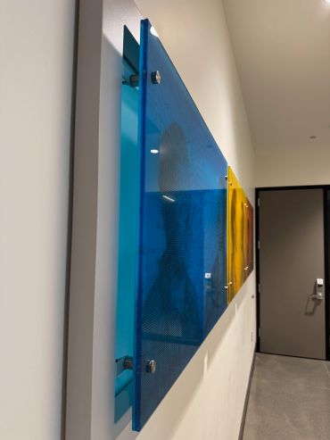 Blue and yellow acrylic panels mounted on a wall.