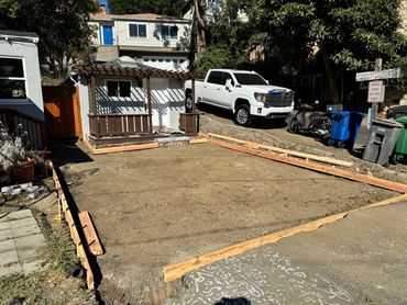 Construction site with wooden framing for a new concrete slab in a residential area.