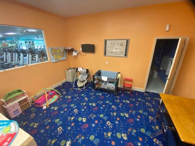 A cozy children's playroom with colorful carpet and toys.