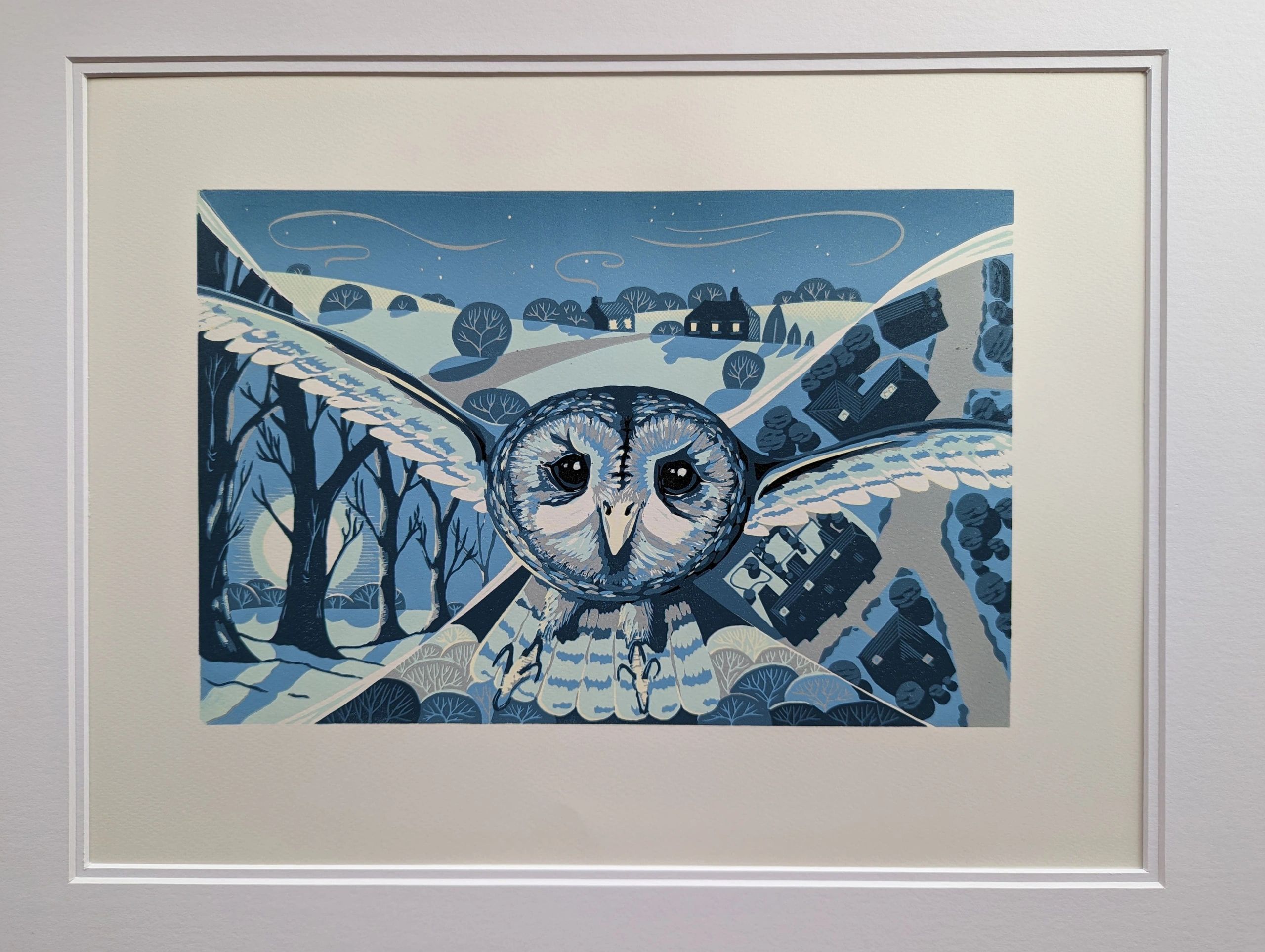 Tawny owl flies above rural landscape in shades of blue.