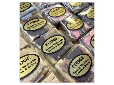 Variety of freshly made fudge with cream and butter in clear packaging.