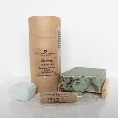 Natural skincare products including shower steamers, lip balm, and soap bars.