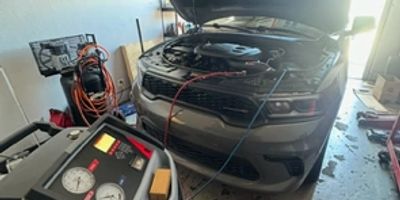 Car undergoing maintenance with diagnostic equipment connected.