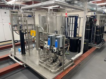 Industrial water filtration system with stainless steel pipes and tanks.