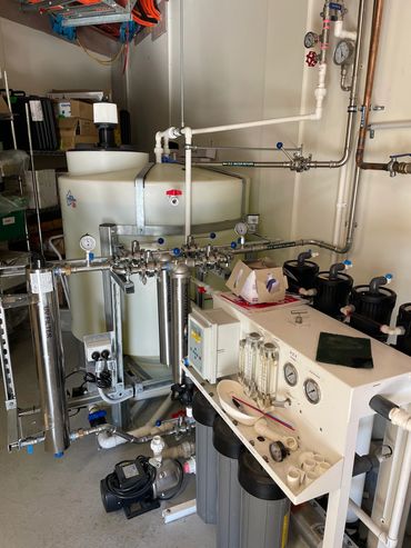 Industrial water filtration and purification system with gauges, pipes, and control panel.