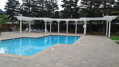 Pavers as pool decking offer variety of design and carefree maintenance. Less costly over time.