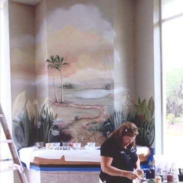 A woman painting a beautiful mural on an empty wall