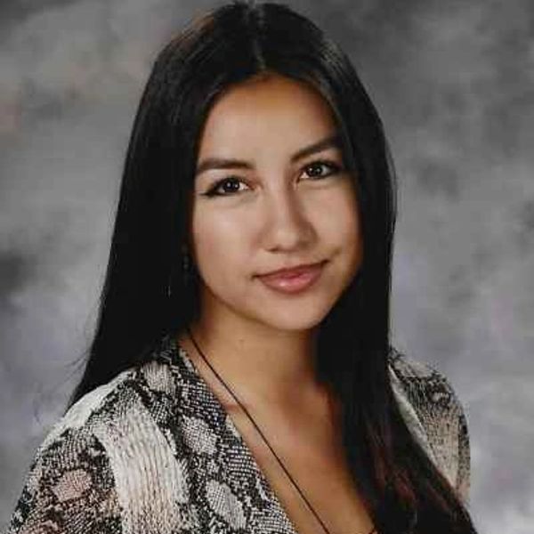 Young woman with long dark hair smiling.