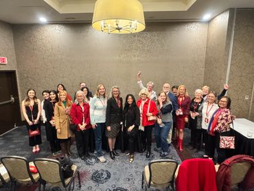 Group photo of diverse adults smiling in a conference room.