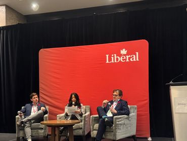 Panel discussion at a Liberal event with three speakers seated on stage.