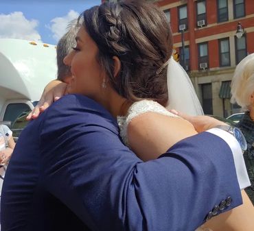 This is a close up image of a bride hugging her godfather. It is adorable.