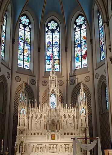 This is an image of the cream colored wedding chapel with tall stained glass windows.