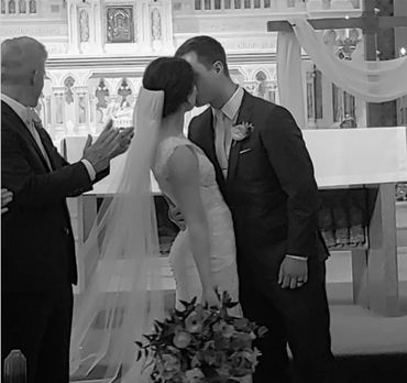 This is a black and white image of the bride and groom's first kiss.