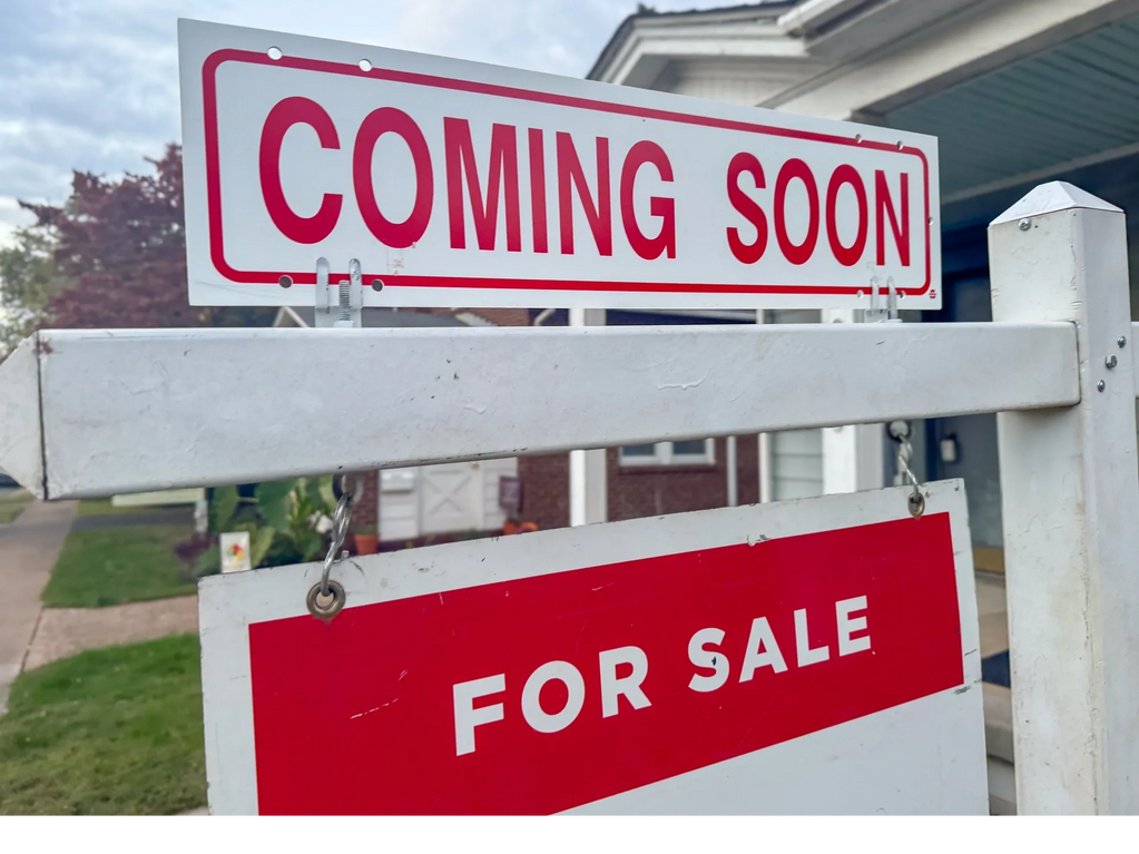 A real estate sign reads "Coming Soon" and "For Sale" in front of a house.