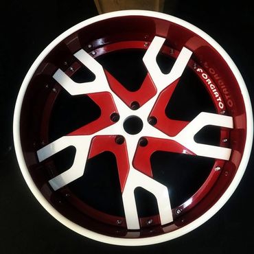 Close-up of a red and white Forgiato car wheel rim.