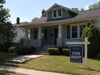 House with a 'For Rent' sign in front on a sunny day.
