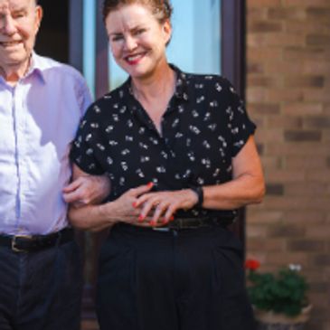 A social worker smiling with an elderly client following an independent care needs assessment