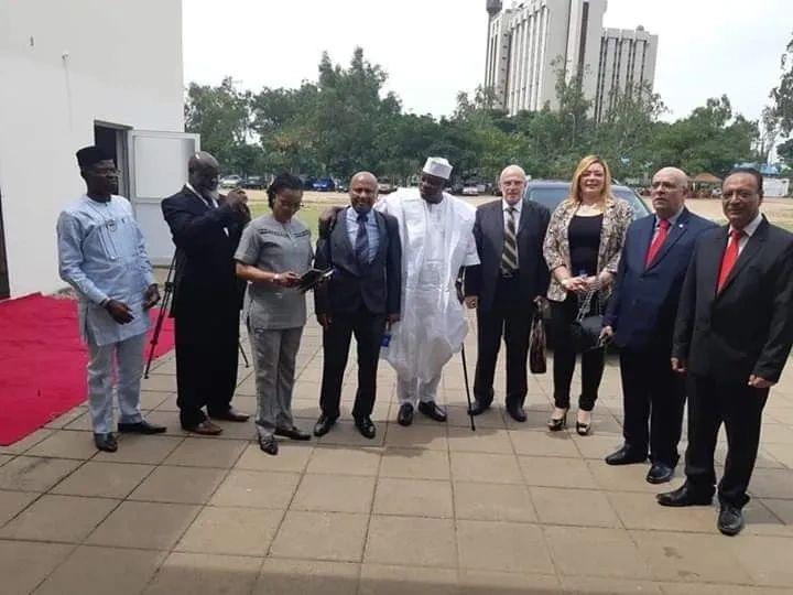 Group of diverse professionals standing outdoors on a tiled floor.