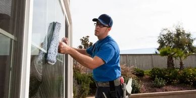 Professional window cleaner cleaning a large outdoor window.