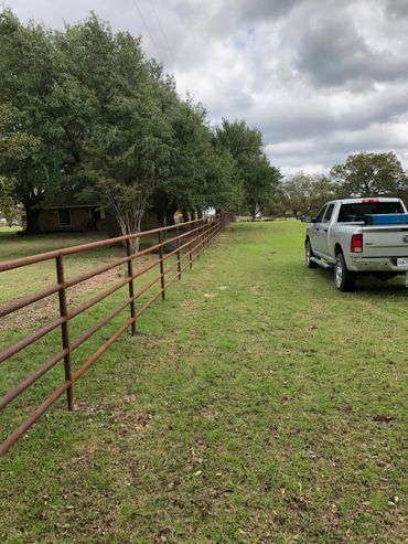 A metal fence running through a field.