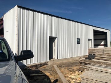 A side view of a metal building with the door open.