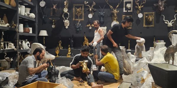 Artisans working on decorative sculptures in a workshop.