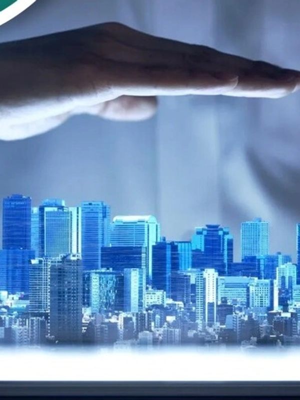 A hand hovers protectively over a digital cityscape projected from a tablet.
