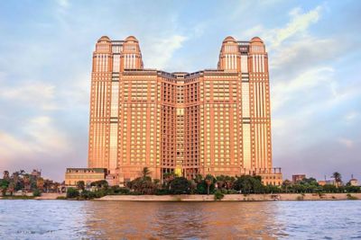 Tall building by the water at sunset.
