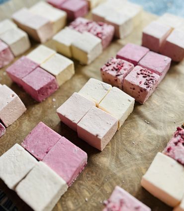 different coloured marshmallows lined up on baking paper