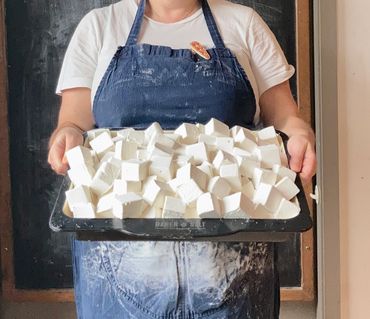 person holding large tray full of vanilla marshmallows