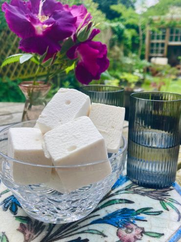 marshmallows in a pretty glass bowl next to wine glasses
