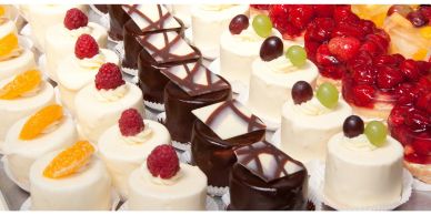 Assorted mini cakes decorated with fruit and chocolate.