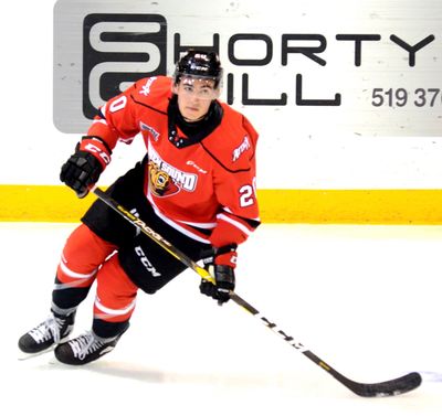 Ice hockey player in red jersey skating on ice with hockey stick.